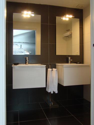 a bathroom with two sinks and two mirrors at Bekale in Ea