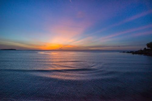 a sunset on a beach with the ocean at Samui Paradise Chaweng Beach Resort in Chaweng