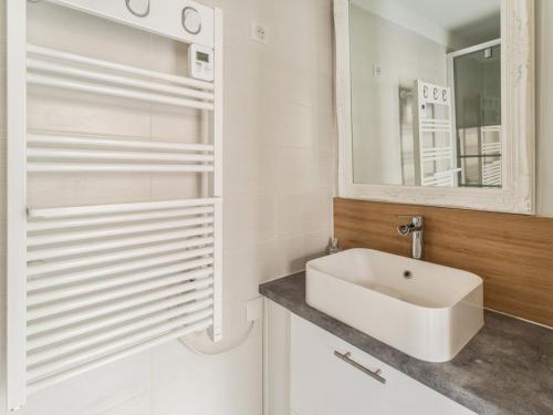 Baño blanco con lavabo y espejo en Welkeys - Bonne Nouvelle Apartment en París