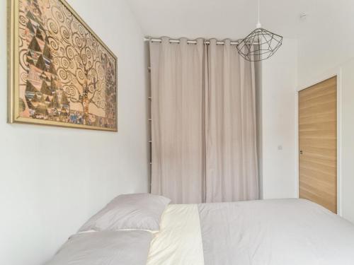 1 dormitorio con 1 cama y una foto en la pared en Welkeys - Bonne Nouvelle Apartment en París