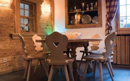 a wooden table and chairs in a room at Hotel Kernen in Gstaad