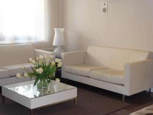 a living room with two white couches and a coffee table at Hotel Desenzano in Desenzano del Garda