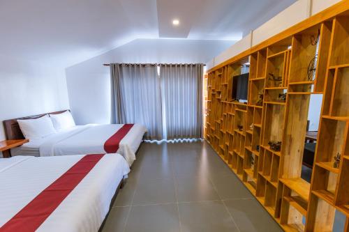 a hotel room with two beds and a tv at Sandy Clay Bungalows in Sihanoukville