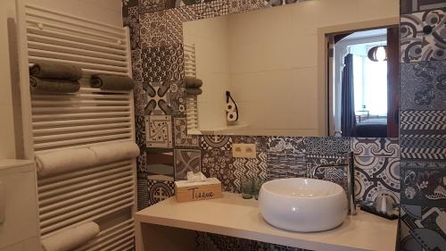 a bathroom with a sink and a mirror at B&B Charles Cabour in De Panne