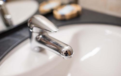 a bathroom sink with a silver faucet at Hotel Kernen in Gstaad