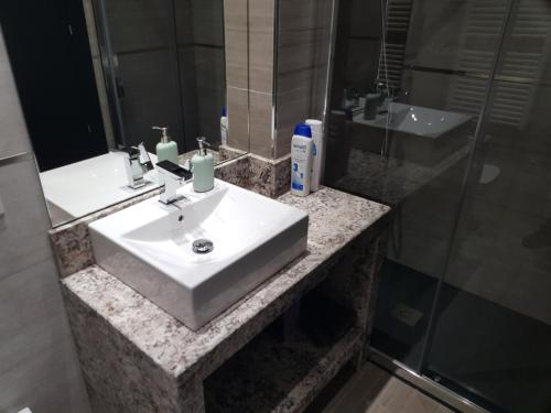 a bathroom with a white sink and a shower at Star Wars Apartment in Salamanca