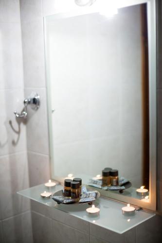 a bathroom with a mirror and a shelf with candles at Kasimidis Apartments in Siviri