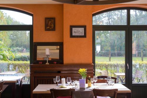 a restaurant with tables and chairs and large windows at Gasthaus Luthemuhle in Nettetal