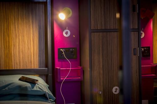 a room with a bed and a pink wall at Kick Ass Greyfriars (18+) in Edinburgh