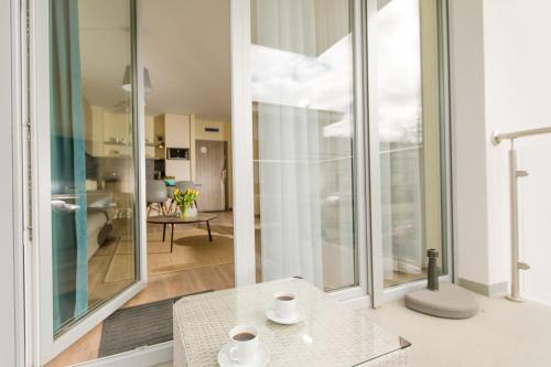 uma sala de estar com portas de vidro e uma mesa em Resort Apartamenty Klifowa Rewal 2 em Rewal