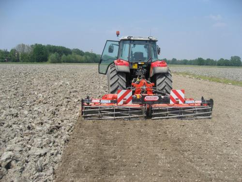 a tractor in a field with a implement at Agriturismo Le Risaie in Basiglio
