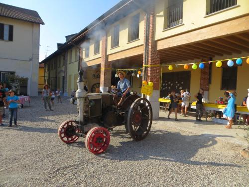 a person sitting on an antique tractor on a street at Agriturismo Le Risaie in Basiglio