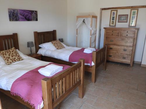a bedroom with two beds and a dresser at Vergecosse in Vergisson