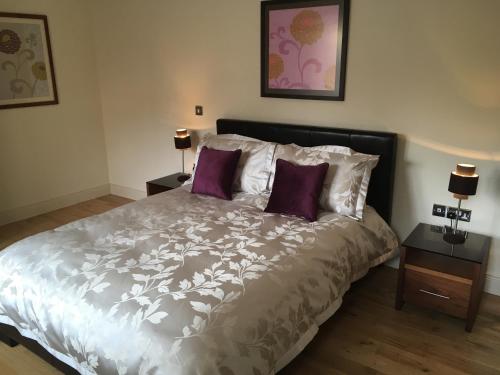 a bedroom with a large bed with purple pillows at Beautiful Killarney Apartment in Killarney