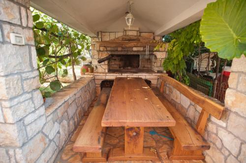 an outdoor patio with a wooden table and a stone fireplace at Apartments Maric with parking in Umag