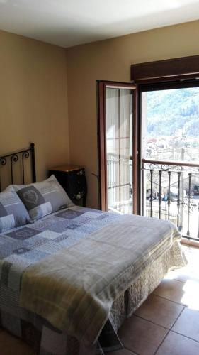 a bedroom with a bed and a large window at Las Cabraliegas in Arenas de Cabrales