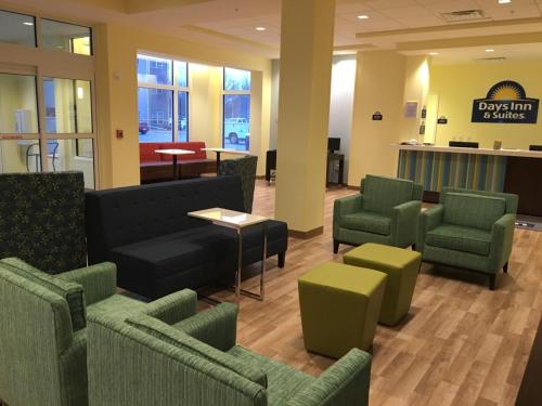 a lobby with green chairs and a waiting room at Days Inn & Suites by Wyndham Kearney NE in Kearney