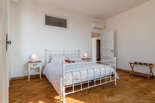 a white bed in a white bedroom with wooden floors at PADOVA TOWER 13TH FLOOR in Padova