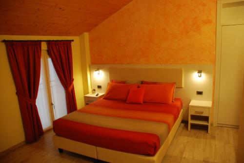 a bedroom with a large bed with red pillows at Agriturismo Le Risaie in Basiglio