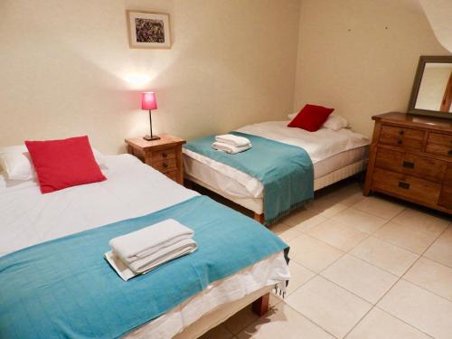 a bedroom with two beds and a dresser and a mirror at Vergecosse in Vergisson