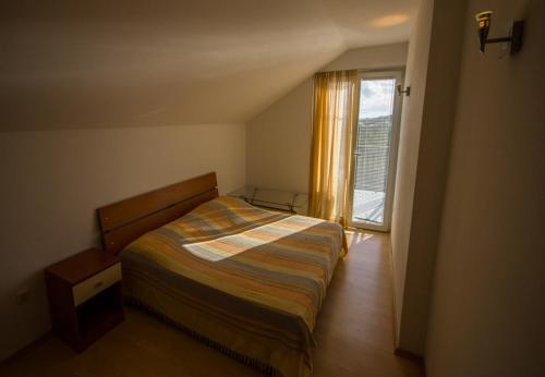 een kleine slaapkamer met een bed en een raam bij Apartments Daju - 3 colours in Ždrelac