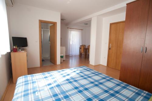 a bedroom with a bed with a blue and white blanket at Apartments Maric with parking in Umag