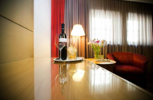 a room with a table with wine glasses and a chair at Boutique Hotel Das Tigra in Vienna