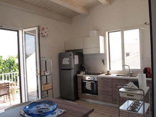 a kitchen with a stainless steel refrigerator and a table at La Casa Di Pina in Sampieri