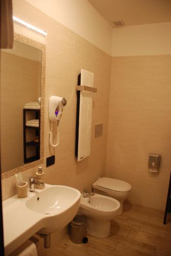 a bathroom with a sink and a toilet and a mirror at Agriturismo Le Risaie in Basiglio