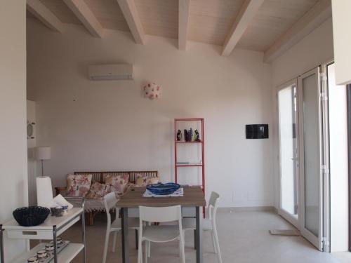 a living room with a wooden table and chairs at La Casa Di Pina in Sampieri