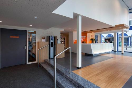 an office lobby with a staircase and a refrigerator at easyHotel The Hague Scheveningen Beach in Scheveningen