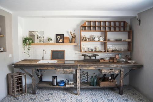 uma cozinha com uma grande mesa de madeira e um lavatório em Le Molina B&B em Massa e Cozzile