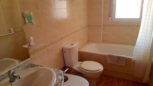 a bathroom with a toilet and a sink and a tub at Los Miradores in La Manga del Mar Menor