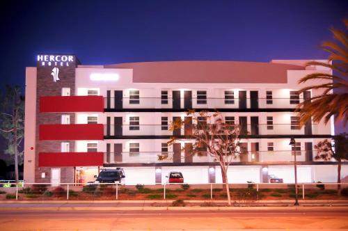 a white building with a sign on the side of it at Hercor Hotel - Urban Boutique in Chula Vista