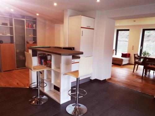 a kitchen with a counter and stools in a room at Haus Korjässer in Löf