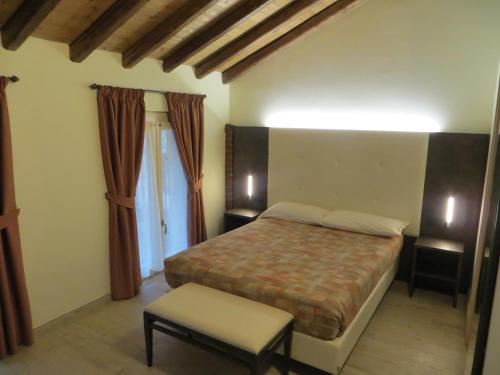 a bedroom with a bed and a chair in it at Agriturismo Le Risaie in Basiglio