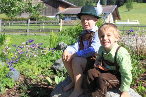 two young boys sitting on rocks in a garden at Huaberhof Weerberg in Weerberg