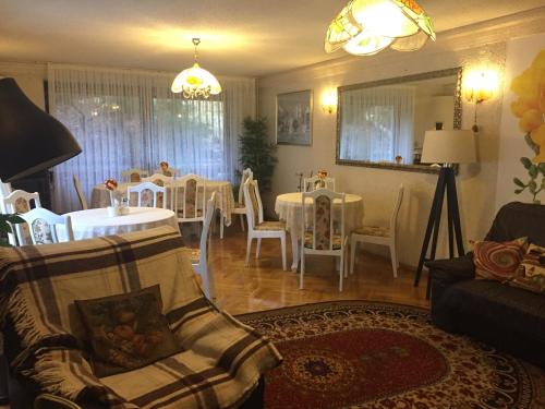 salon z jadalnią ze stołami i krzesłami w obiekcie Villa Almira w Polanicy Zdroju