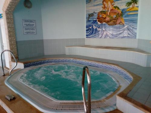 a jacuzzi tub in a bathroom with a painting at Apartment Oásis Comfort in Portimão