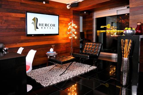 a lobby with a chair and a television on a wall at Hercor Hotel - Urban Boutique in Chula Vista
