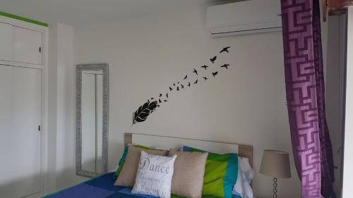 Zimmer mit einem Bett mit einer Gruppe von Vögeln an der Wand in der Unterkunft Apartamento Rulosol 3 in Torremolinos