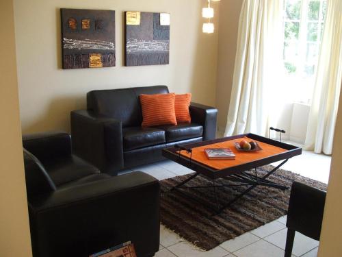 a living room with a couch and a coffee table at Melody Guest House in Centurion