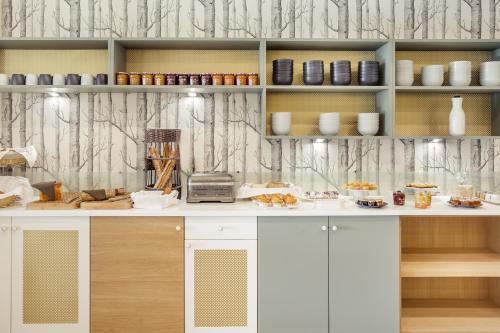 a kitchen with a counter with food on it at Mercure Orléans Portes de Sologne in Ardon