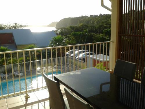 a balcony with a view of a swimming pool at Entre 2 Plages in Le Gosier