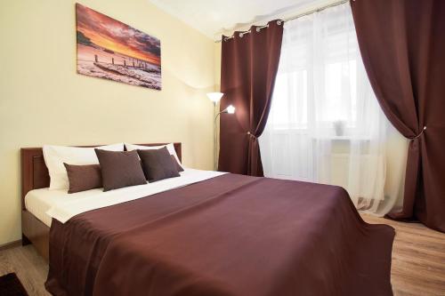 Un dormitorio con una cama grande y una ventana en PaulMarie Apartments on Mazurova, en Gomel