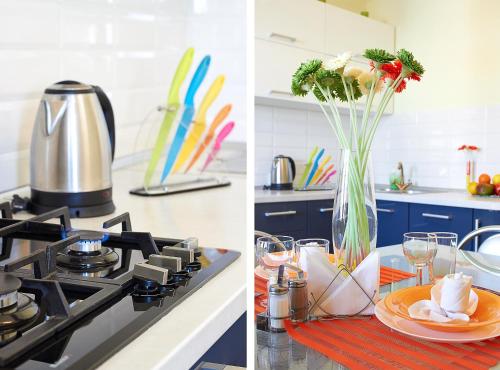 a kitchen with a stove and a table with a vase of flowers at PaulMarie Apartments on Mazurova in Gomel