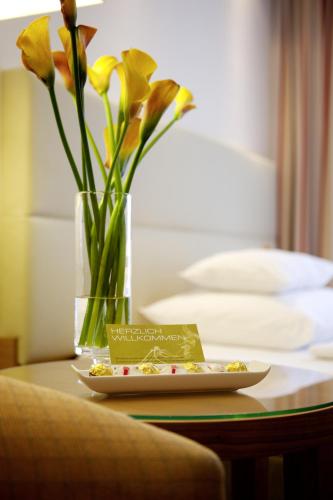 a plate of food on a table with a vase with flowers at Boutique Hotel Das Tigra in Vienna