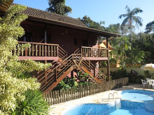 uma casa com um deque e uma piscina em Pousada da Villa Itamambuca em Ubatuba
