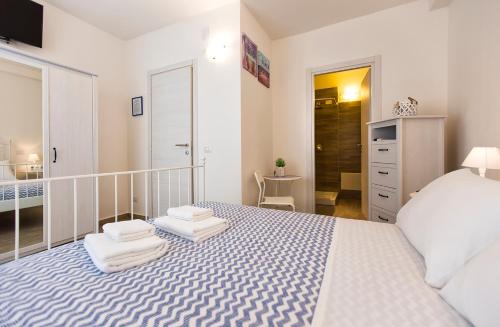 a bedroom with a white bed with towels on it at White Charme Rooms in Alghero