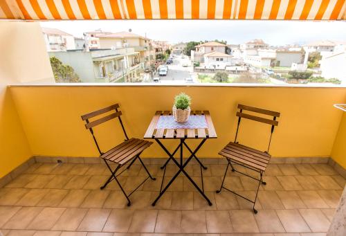 a small balcony with a table and two chairs at White Charme Rooms in Alghero
